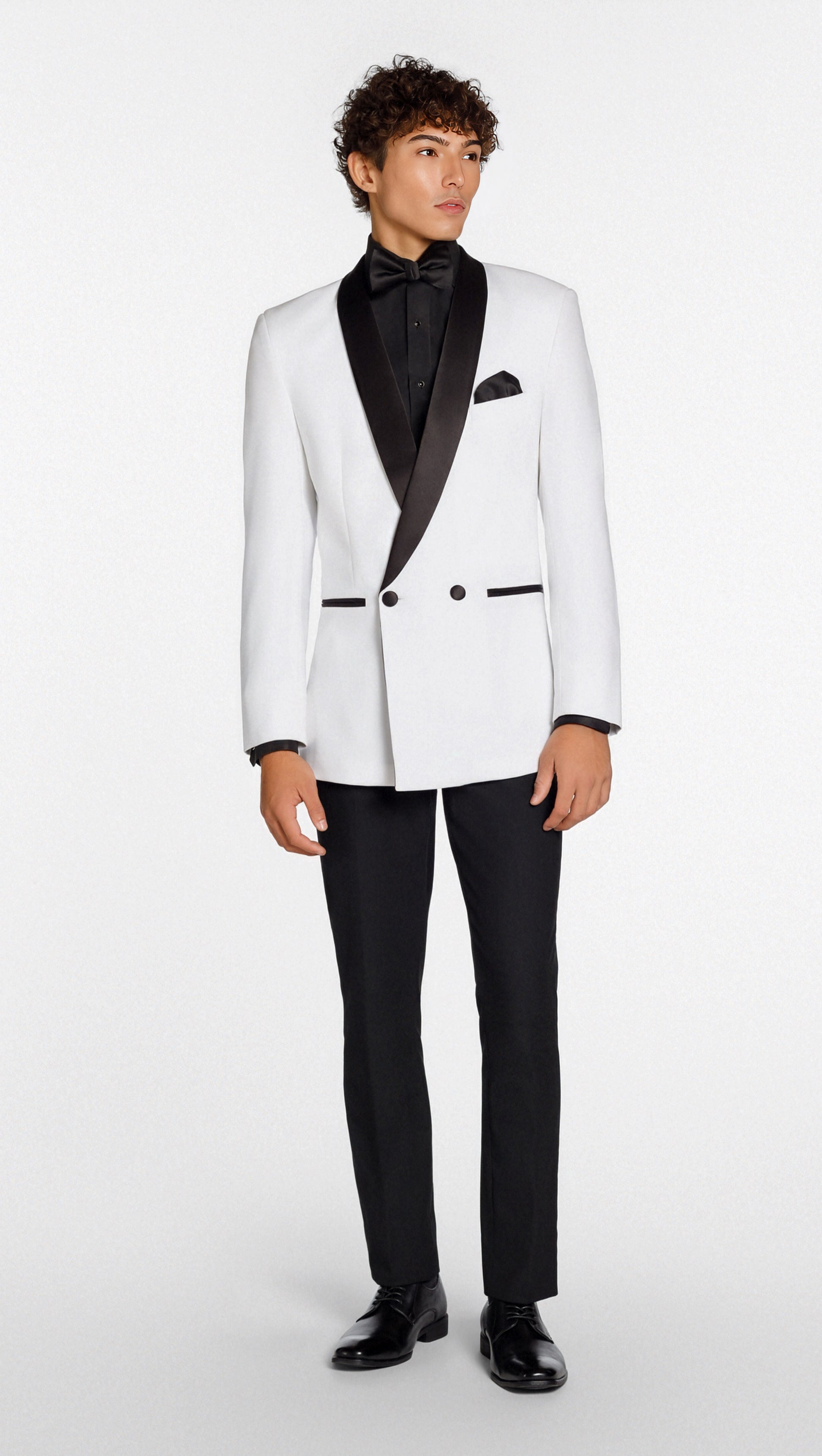 Man wearing a white tuxedo with black lapels and pants on a white background